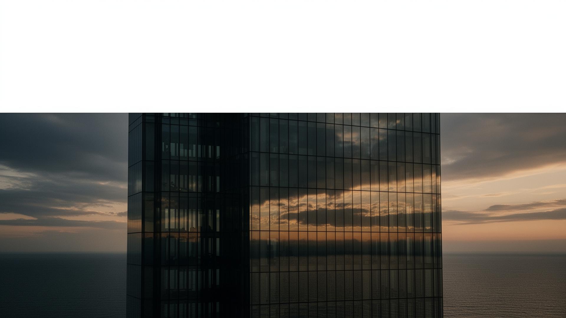 Modern glass tower at dusk over open water